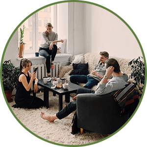 group of friends gathered at a residence sitting around a coffee table