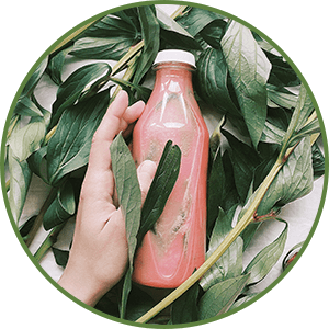 Bottle of Juice laying on greenery - juicing as part of a detox by Dr. Tara Clapp, ND