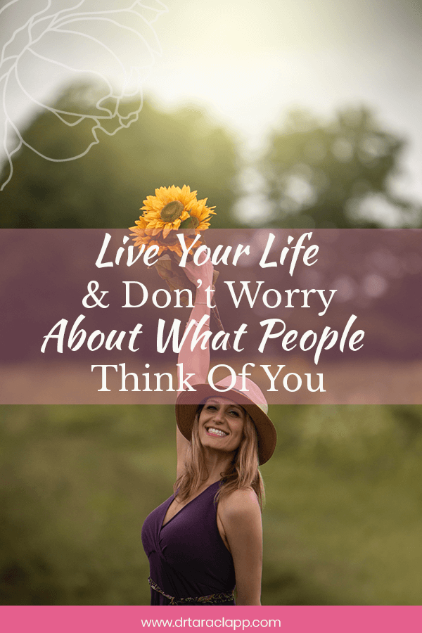woman holding flowers over her head - Live Your Life & Don't Worry About What People Think of You - Article by Dr. Tara Clapp, ND
